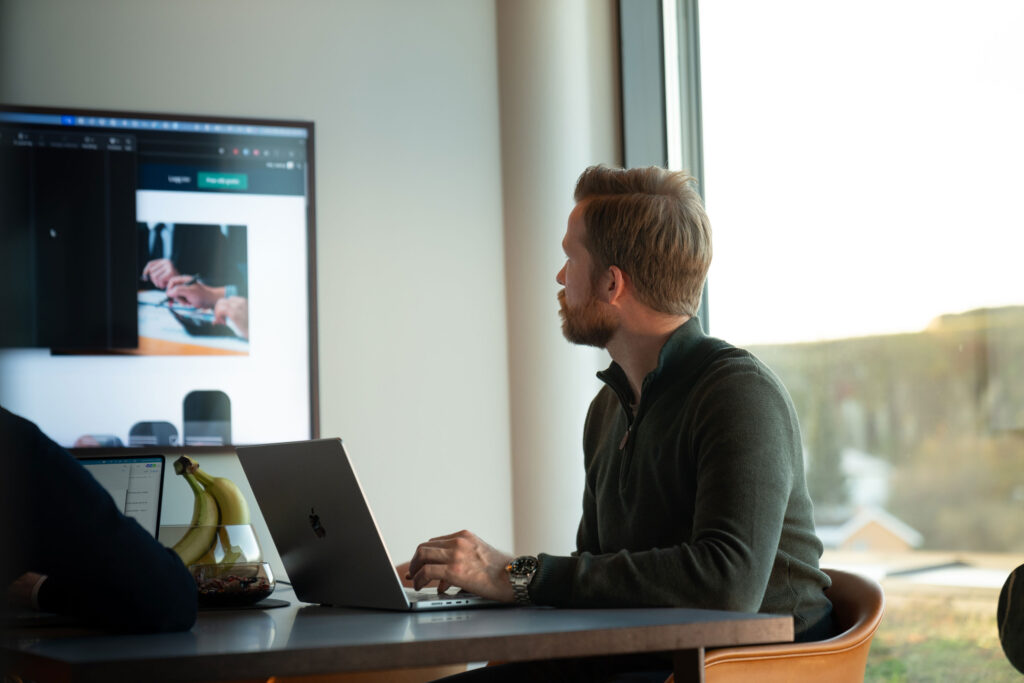 Bilde av en ansatt hos Veniro som ser på en TV-skjerm