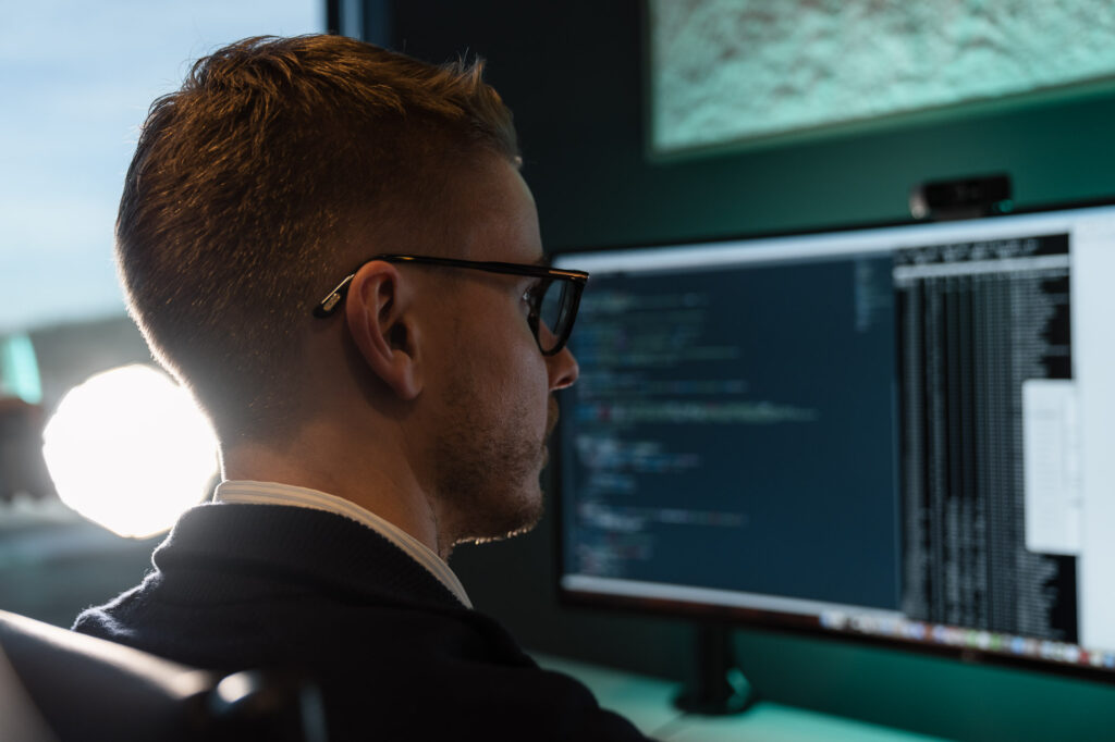 Nærbilde av en uklar skjerm som viser terminal og html kode fra en hjemmeside med bakgrunnslys