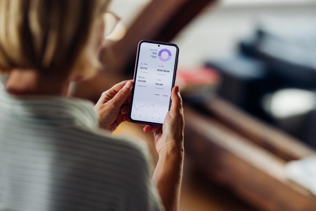 En kvinne som holder en telefon og viser en app