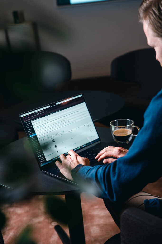 Bilde av en person som sitter og jobber på en PC med en hjemmeside i WordPress